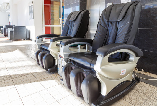 Black leather comfortable reclining massage chairs in resort hotel.