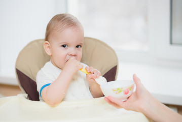 mother feeding her baby breast porridge day