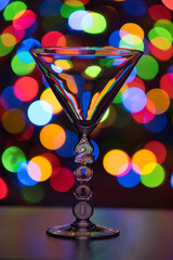 Martini glass on dark, multi-colored bokeh background