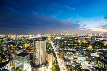 Business and culture concept for real estate and corporate construction - panoramic modern city skyline bird eye aerial night view under dramatic neon glow and beautiful dark blue sky in Tokyo, Japan