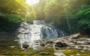 Fototapeta premium Japan travel concept - beautiful yoro keikoku valley waterfall under dramatic sun glow and morning blue sky in Chiba Prefecture, Japan