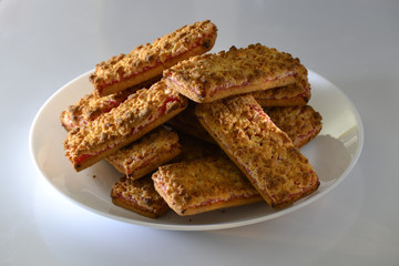 Cookies with strawberry jam on a white plate