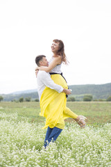 Obraz premium Lovers man and woman walk on the flower field.