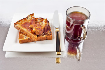 Raisin toast with coffee part eaten on a plate with knife