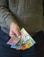 Hand focus handing variety Australian bank notes.