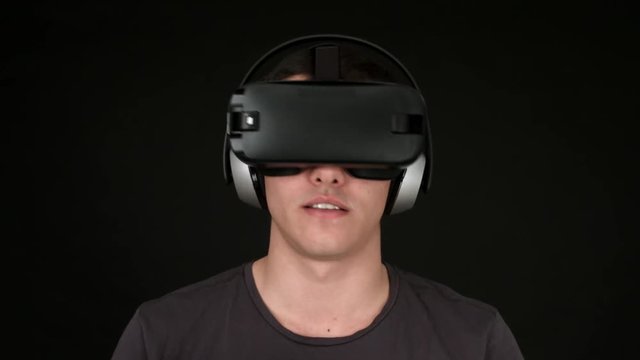 Young man wearing VR Headset and playing virtual reality games. Captured with Blackmagic Production Camera 4K with RAW settings.