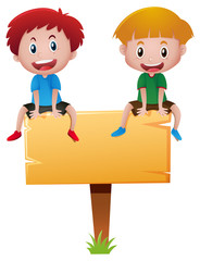 Two boys sitting on wooden sign