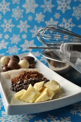 Ingredients for raw chocolate with utensils on blue background  