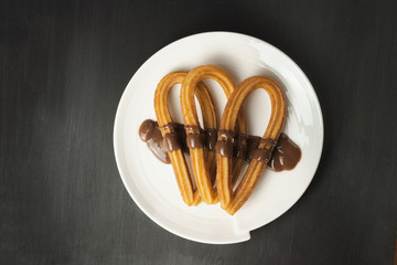 Fototapeta premium Traditional Spanish churros with chocolate on black background w