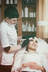 Obraz na płótnie Canvas Cosmetologist applying permanent make up on eyebrows- eyebrow tattoo