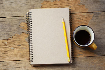 coffee and notebook on wooden table