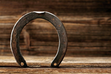 Old rusty horseshoe on wooden background