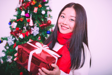 Young woman holding a red christmas gift box.