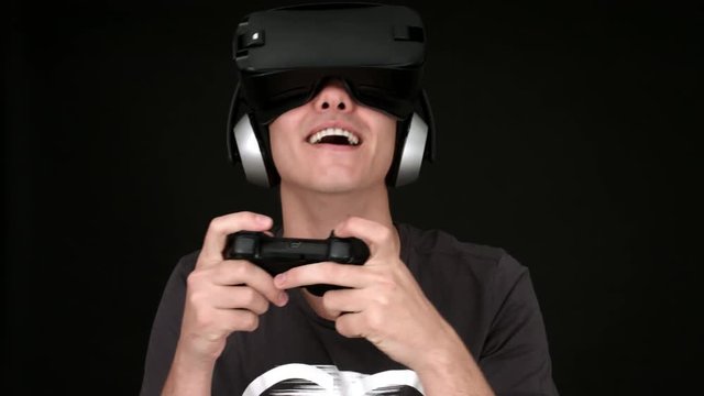 Laughing young man wearing VR Headset and playing virtual reality games. Captured with Blackmagic Production Camera 4K with RAW settings.