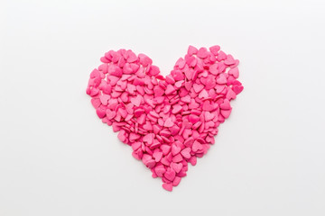 Obraz na płótnie Canvas pink heart made of small hearts on a white background. festive background for birthday, Valentine's day, wedding, celebration.