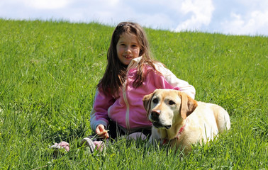 beautiful smiling little girl with labrador dog