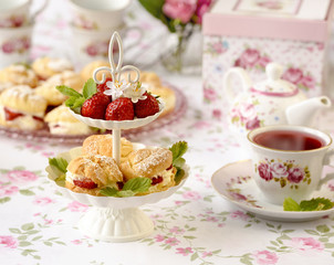 Profiterole or cream puffs cakes filled with whipped cream, strawberries in plateau