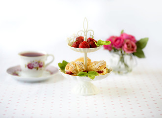 Profiterole or cream puffs cakes filled with whipped cream, strawberries in plateau