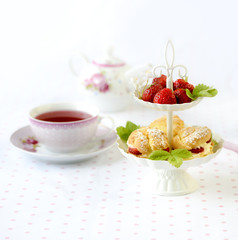 Profiterole or cream puffs cakes filled with whipped cream, strawberries in plateau