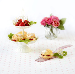Profiterole or cream puffs cakes filled with whipped cream, strawberries in plateau