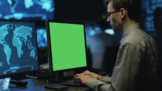 Concentrated Programmers Work on Personal Computers Located in a System Control Room. Computer has Green Screen.