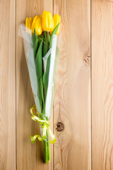 a bouquet of yellow tulips on wooden boards close-up