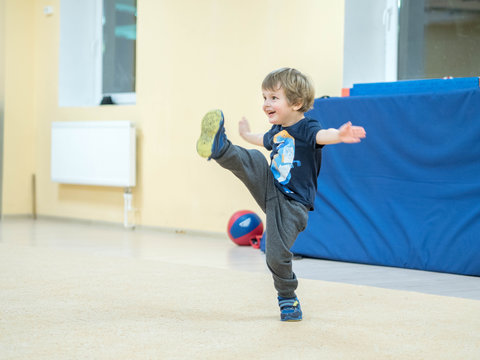 Cute little boy is engaged in martial arts. The baby kicks and punches imaginary enemy. Overall complexes exercises Kungfu.