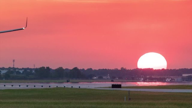 Commercial Passenger Airliner Landing during Vibrant Sunset in Texas Heat with Smoke Bursting from the Tires when Touching Down onto the Runway