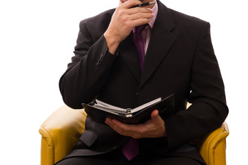 Geschäftsmann überlegt beim Eintragen in Terminkalender