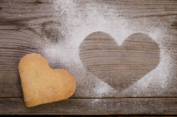 Obraz premium mark in shape of heart with powdered sugar and cookie