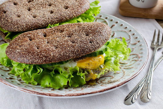 Healthy food - sandwiches of dark bread and poached eggs.