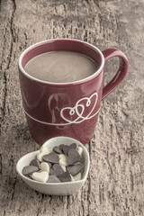 coffee and heart shaped chocolates on wooden table