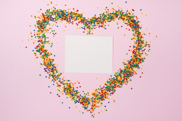 Fototapeta na wymiar Valentines Day background. Heart shape with candies on pink.