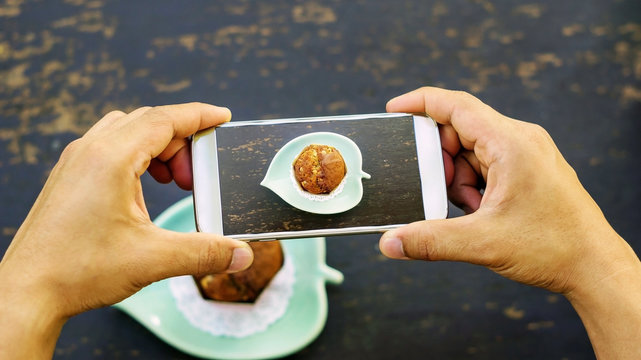 Men take a photo of muffin cake.