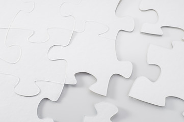Obraz premium White jigsaw puzzle on white background. Blank puzzles, mock up.