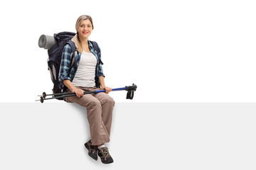 Happy female hiker sitting on a panel