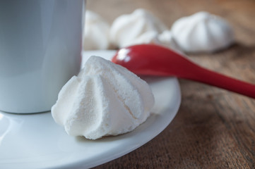 meringues et tasse de café avec une petite cuillère rouge