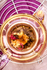 Glass teapot with tea on cooling rack. Concrete background. Top view.