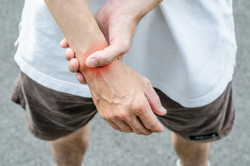 Wrist pain. Male holding hand to spot of wrist pain.