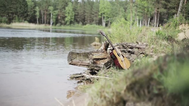 Nature. The forgotten guitar on the bank of the lake.