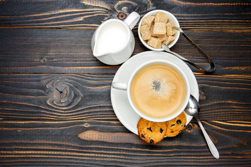 cup of coffe and cinnabon on wooden background
