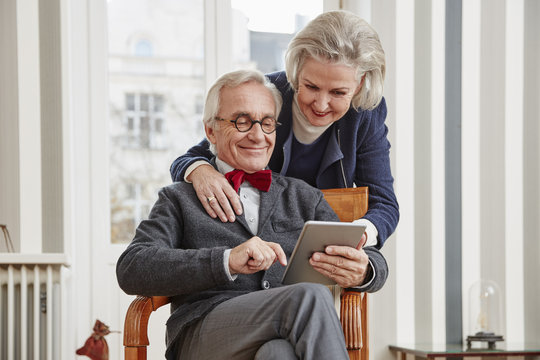 Smiling senior couple using tablet