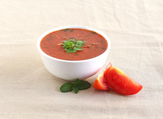 Healthy raw vegetarian food tomato curry in a bowl and slices of tomato.