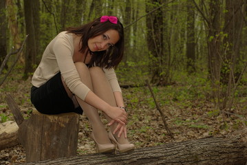 Pretty girl sitting on a stump
