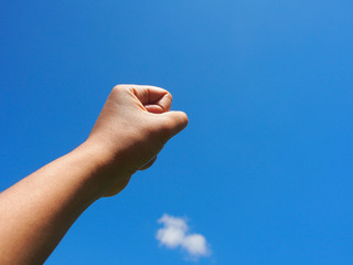 Hand in blue sky