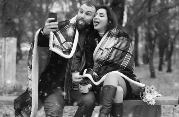 date in a park lovers on a bench in snow