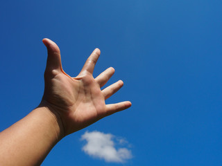 Hand in blue sky