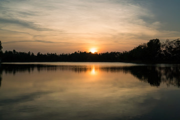 sunset on the river with reflex - reflection in the water surface, Sunset on the lake with trees sillouette