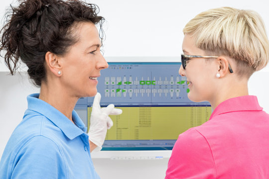 Zahn&auml;rztin bespricht  Zahnschema eines Patienten mit Assistenti