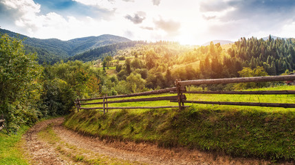 Fototapeta na wymiar Beautiful summer landscape with wooden fence and mountains. blue